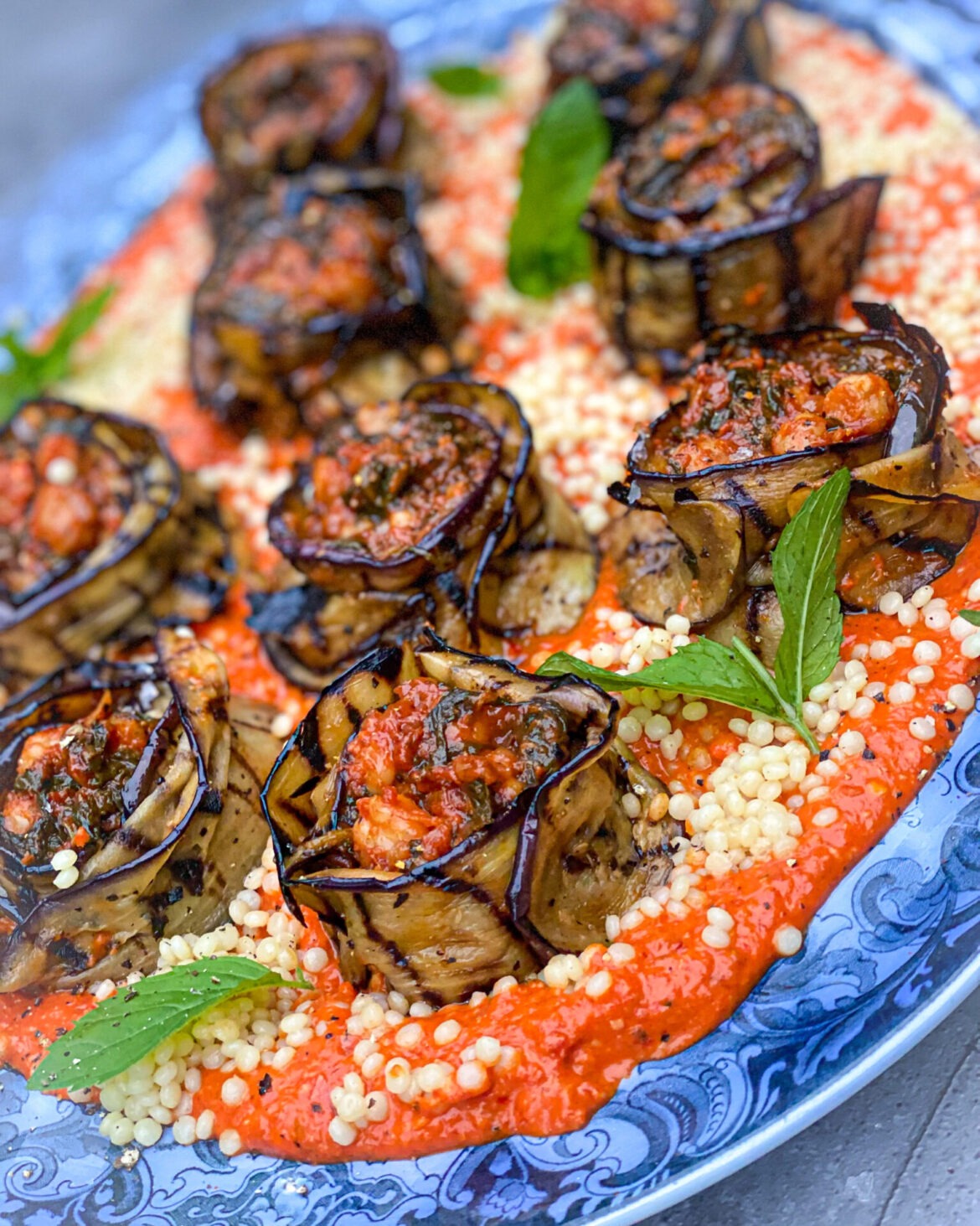 Spicy Chickpea Spinach Aubergine Roses On A Bed Of Roasted Red Pepper Harissa Cream Sauce With Pearled Cous Cous Jewels
